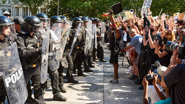 Picture of people vs police at a rally.